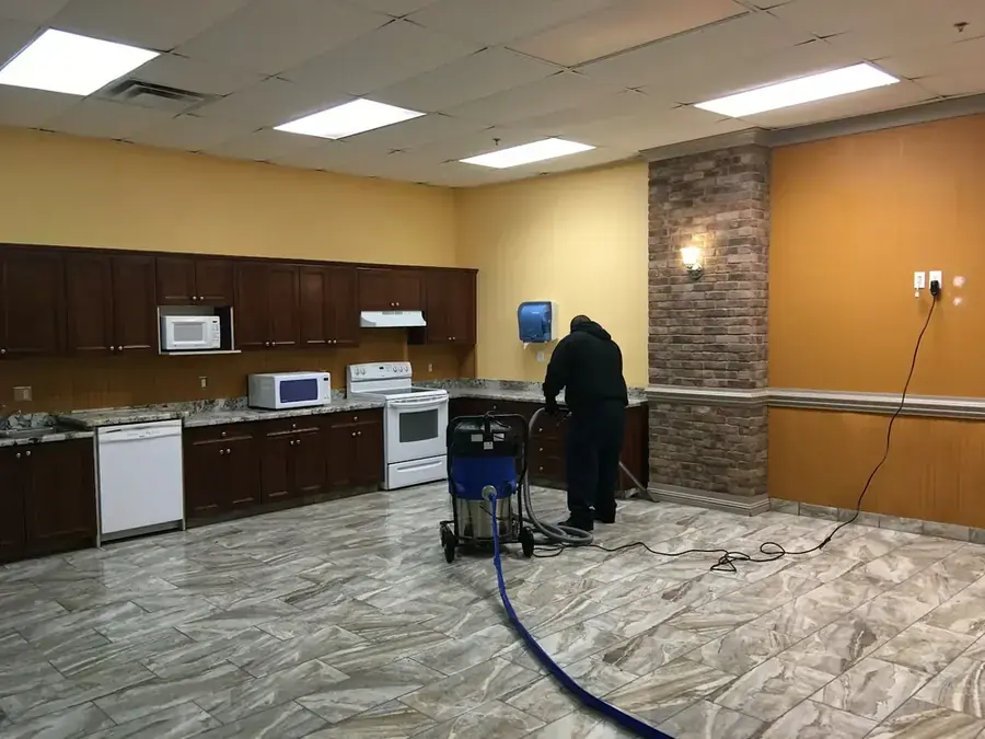 Technician extracting standing water from a Peoria, AZ tile floor